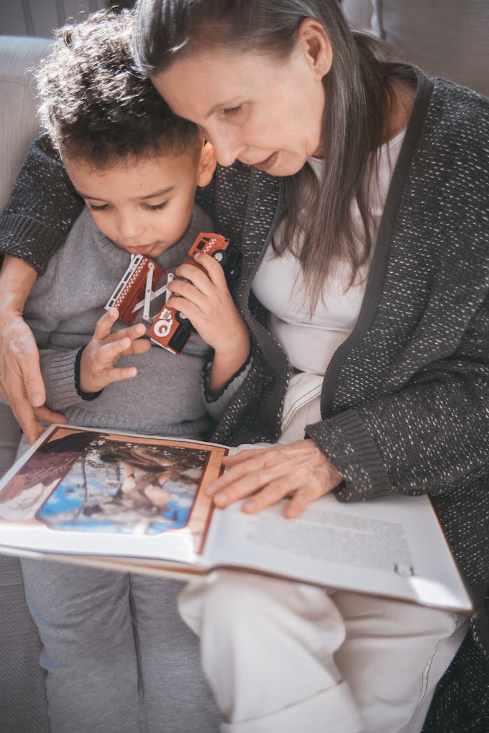 Grandmother and child sharing a moment reading a picture book at home.